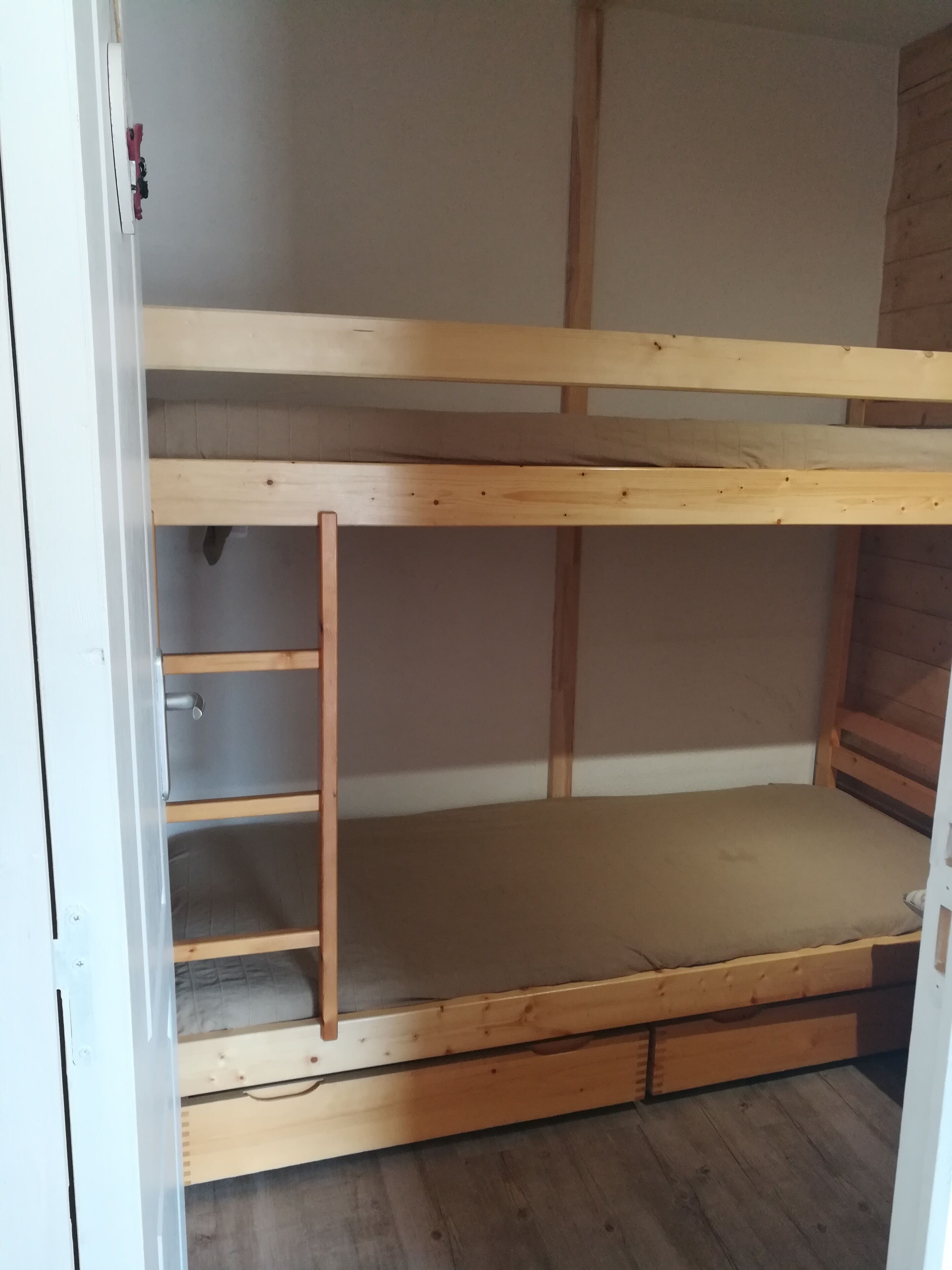 A bunk bed with a wooden frame and a mattress.