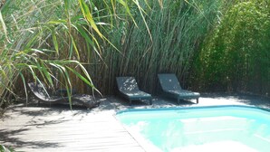 A pool area with two lounge chairs and a bamboo backdrop. - Charming Villa of 150m2 with swimming pool and garden near sea (Carry-Le-Rouet)