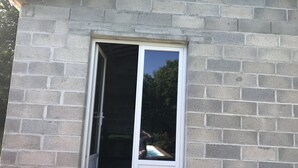 Une porte-fenêtre coulissante donne accès à un espace piscine, devant laquelle se trouve une terrasse en bois.