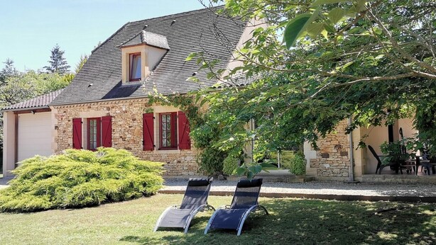 A stone house with a sloped roof, red shutters, and a small window. There are two lounge chairs in the front yard. - Périgourdine gîte (air-conditioned) 5kms from SARLAT, enclosed grounds. (Carsac-Aillac)