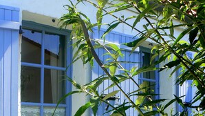 Un edificio con contraventanas azules y un encaje en la ventana.