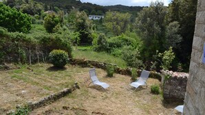 A garden with two lounge chairs and a stone wall. - TYPICAL VILLAGE HOUSE CORSE  (Levie)