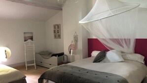 A bedroom with a bed, a bedside table, a chair, a hanging light fixture, and a wall-mounted shelf. - CHARTER OF YESTERYEAR (Sainte-Eulalie)