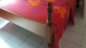 A bedroom with a bed, a nightstand, a lamp, and two wall-mounted pictures. - Nice apartment perfect also for people with reduced mobility (Sainte-Anne)