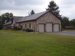 Un bâtiment en pierre avec un toit en pente et trois portes de garage.