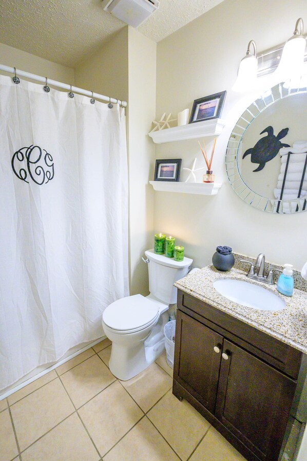 A bathroom with a toilet, sink, and shower curtain.