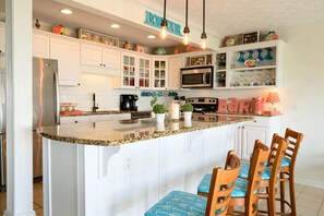Enjoy cooking in this well-equipped kitchen with a central island, double oven, and bar area.