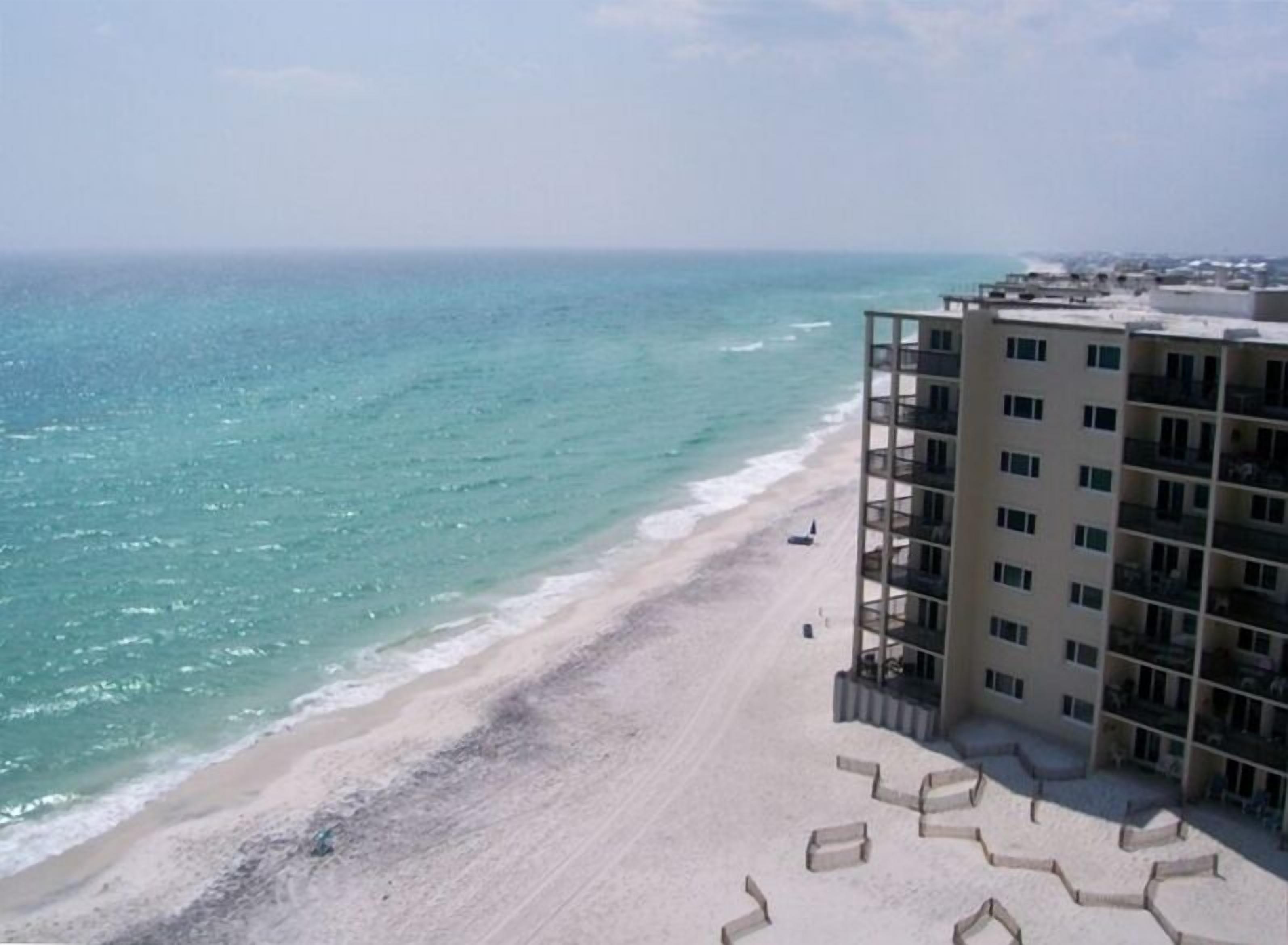 Ein Hotel direkt am Strand mit Sand und Blick auf den Ozean.