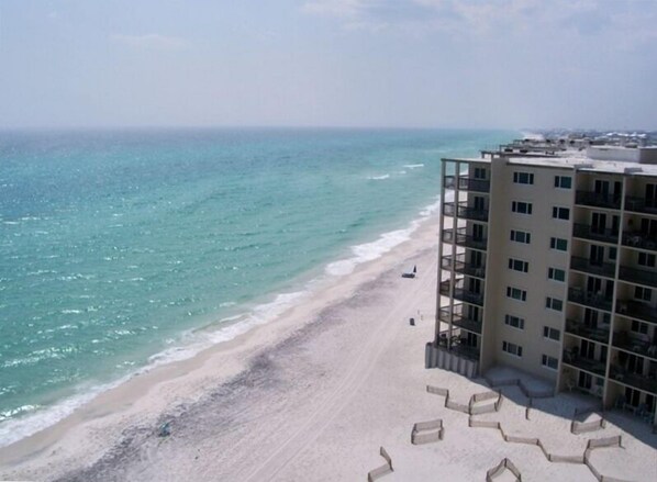 A beachfront hotel with a sandy beach and ocean view.