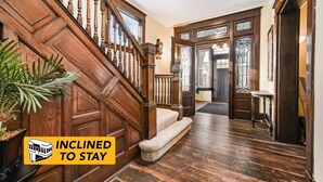 A wooden staircase leading to a door with a glass panel, a bench, and a potted plant. - Family-Focused Victorian In Quiet Area, Pets OK, Yard & Parking (Pittsburgh)