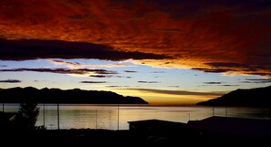 A sunset over a calm lake with mountains in the background.