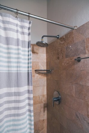 Een douche, handdoeken, zeep, shampoo