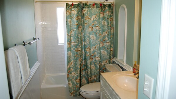 Une salle de bain avec une baignoire, des toilettes et un lavabo.