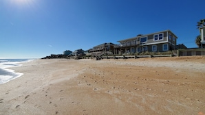 A beachfront property with a large house featuring multiple balconies and a wooden deck. - Oceanfront House with Private Beach, Patio, and Gameroom (Ponte Vedra Beach)