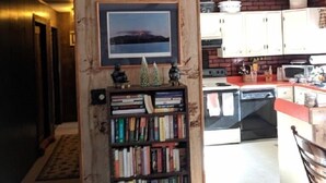 Une cuisine dotée de meubles en bois, d’une bibliothèque intégrée et d’un ventilateur de plafond.