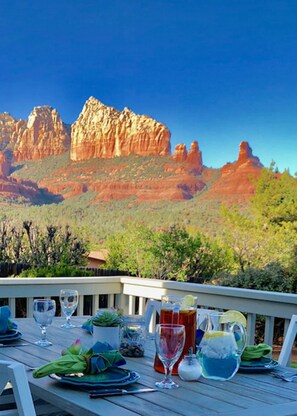 A dining table set outdoors with a view of red rock formations. - Spectacular Sedona,  Sunrise to Sunset! (Sedona)