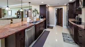A modern kitchen with dark wood cabinets, stainless steel appliances, and a granite countertop.