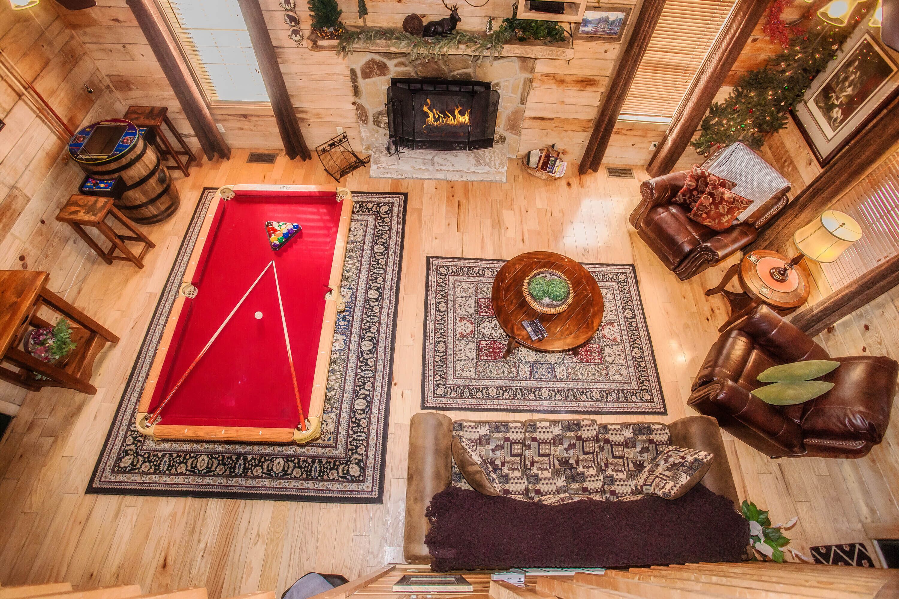 A cozy room with a pool table, a fireplace, and a comfortable seating area.