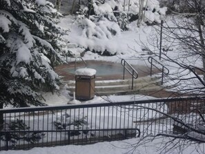 Enjoy serene winter moments in this peaceful outdoor space with a bench and metal railing.