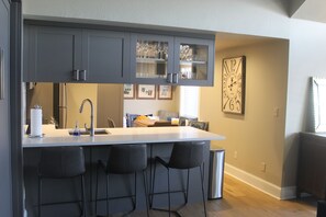 Enjoy cooking in this well-equipped kitchen with a central island, sink, and bar stools.