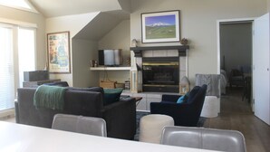 Un salon avec une cheminée, un téléviseur et un coin repas.