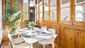 A dining area with a table set for four, surrounded by wooden cabinets and a potted plant. - The Classic Apartment (Barcelona)
