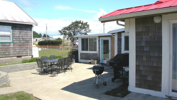 Un patio con una parrilla y mobiliario exterior.