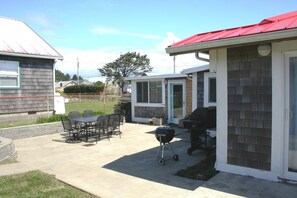 A patio with a grill and outdoor furniture. - Hot Tub - 1/2 Block to the Beach - Family & Dog Friendly. (Moclips)