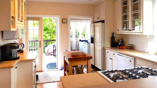 A kitchen with white cabinets, a stove, and a refrigerator.