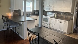 A modern kitchen with white cabinets, a central island, and a built-in oven. - LBJ Waterfront Retreat-Large Quiet Cove, Great Views, Family Friendly, Discounts (Granite Shoals)