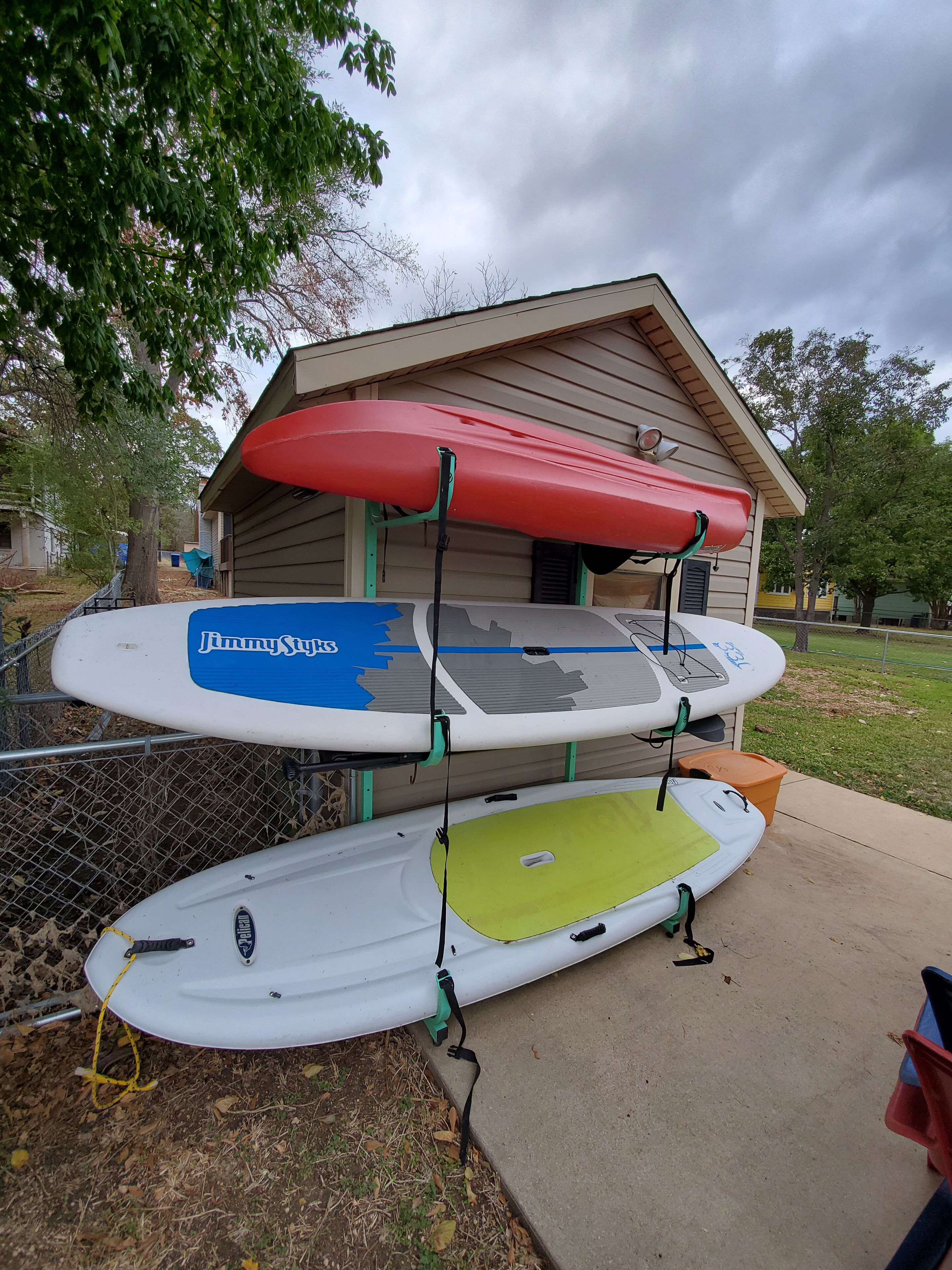 Three kayaks mounted on a house's porch.