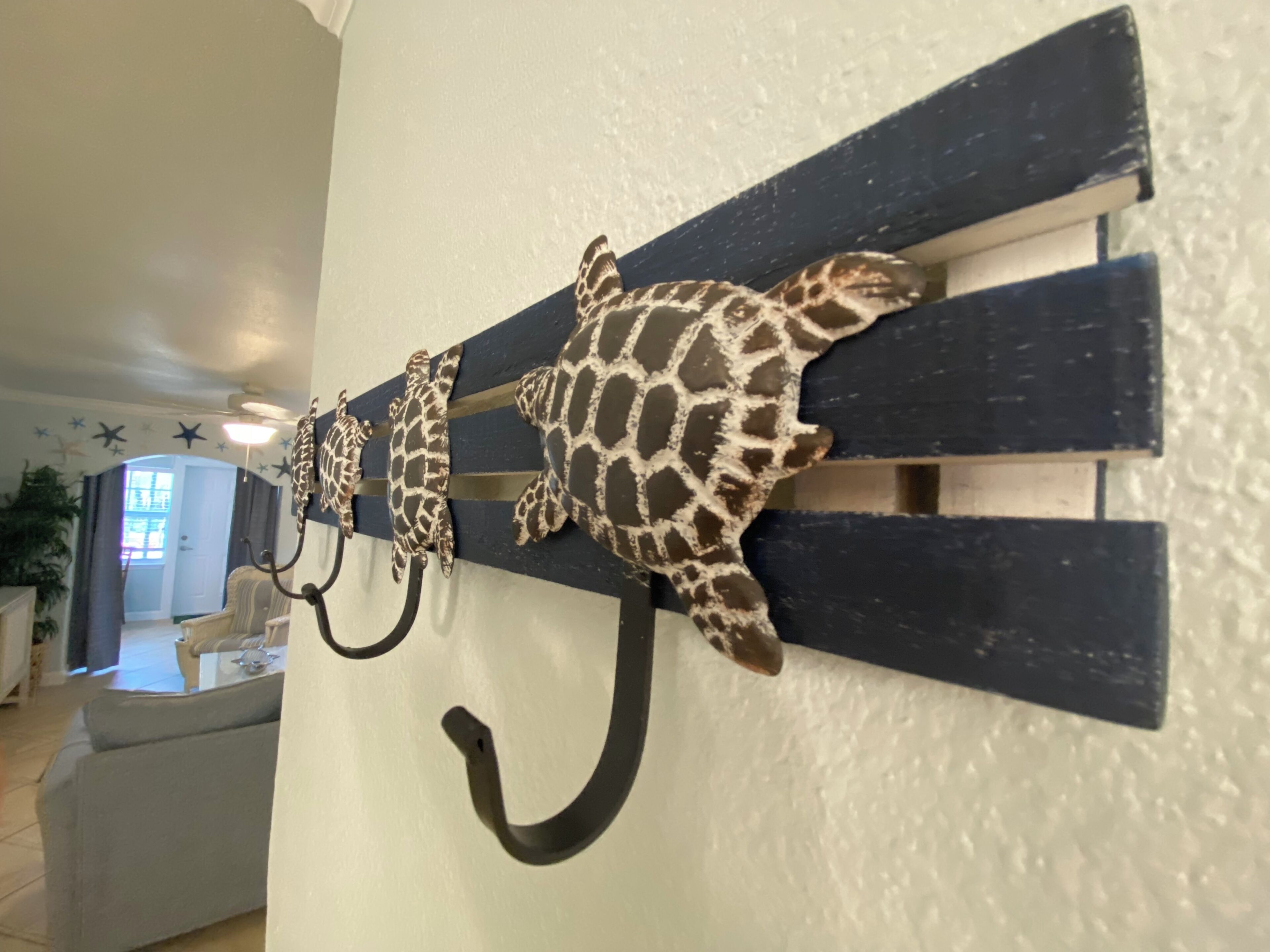 A wall-mounted coat rack with three turtle-shaped hooks.