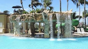 Un espace piscine agrémenté d’un élément décoratif aquatique et de palmiers.
