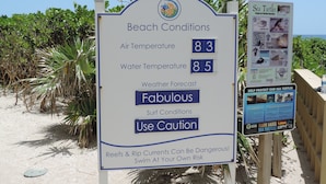 Un panneau d’information sur la plage indiquant les conditions météorologiques, la température et les prévisions.