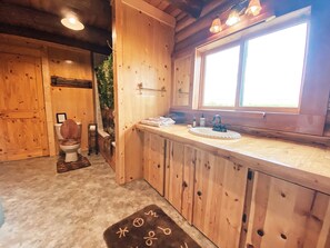 Een bad/douchecombinatie, een haardroger, handdoeken, zeep