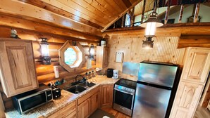 A kitchen with wooden cabinets, a stainless steel refrigerator, a built-in oven, and a granite countertop. - Perfect for Couples Or Families Up To 4 In Lovely Two Story Log Home  (Big Timber)