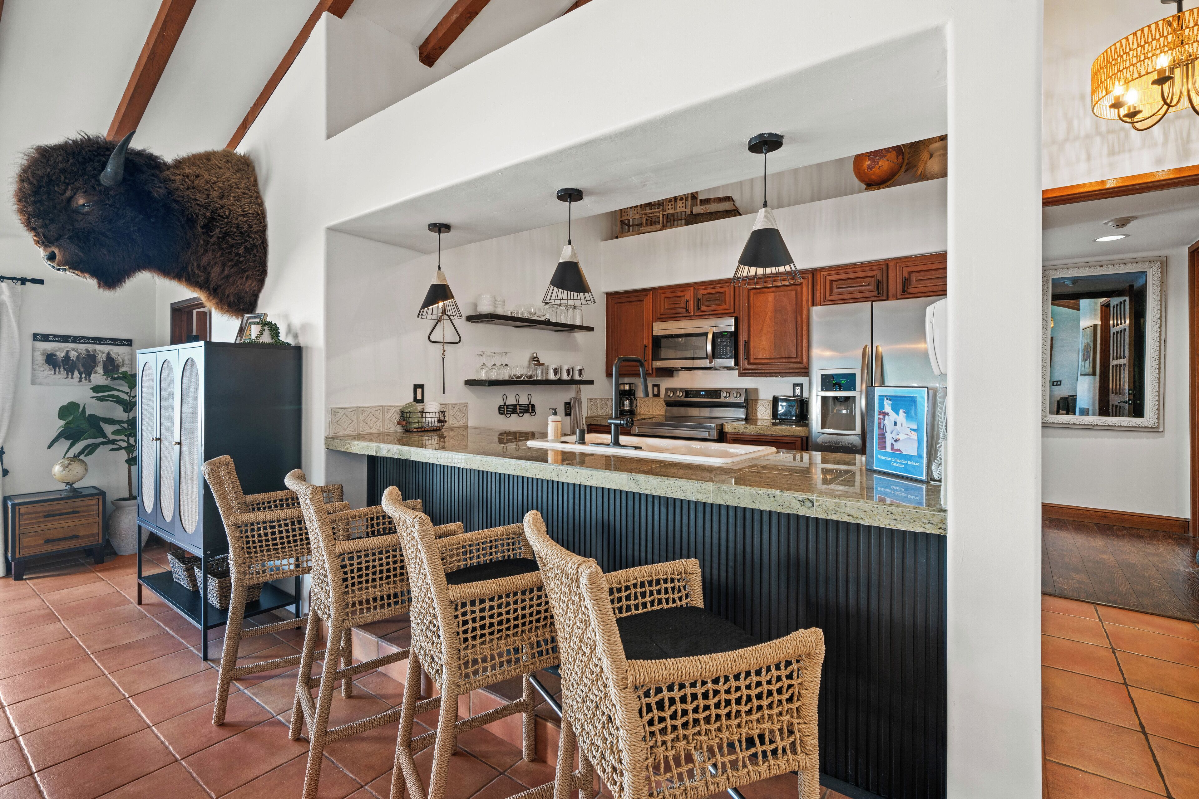 Una cocina con barra, armarios de madera y una cabeza de animal montada.