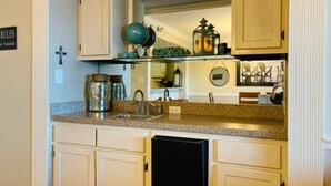 A compact kitchen with a granite countertop, a coffee maker, and a dishwasher. - Fantastic place to make memories. Great ocean view condo for fun & “GOOD TIMES” (Pawleys Island)