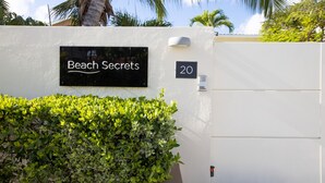 A white wall with a black sign reading "Beach Secrets" and the number "20" on it. - BEACHFRONT DESIGN VILLA (Beacon Hill)