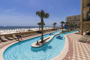 Relax by the pool with a clear view of the ocean and beach, featuring multiple lanes for swimming and floating.