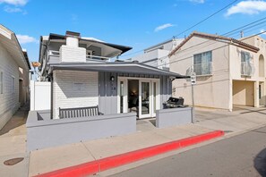 Une maison de vacances dotée d’un balcon, d’un barbecue et d’une pancarte indiquant qu’il s’agit d’une location de vacances.