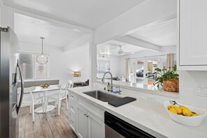 Enjoy cooking in this well-lit kitchen with a large island and ample counter space, featuring a dishwasher and large sink.