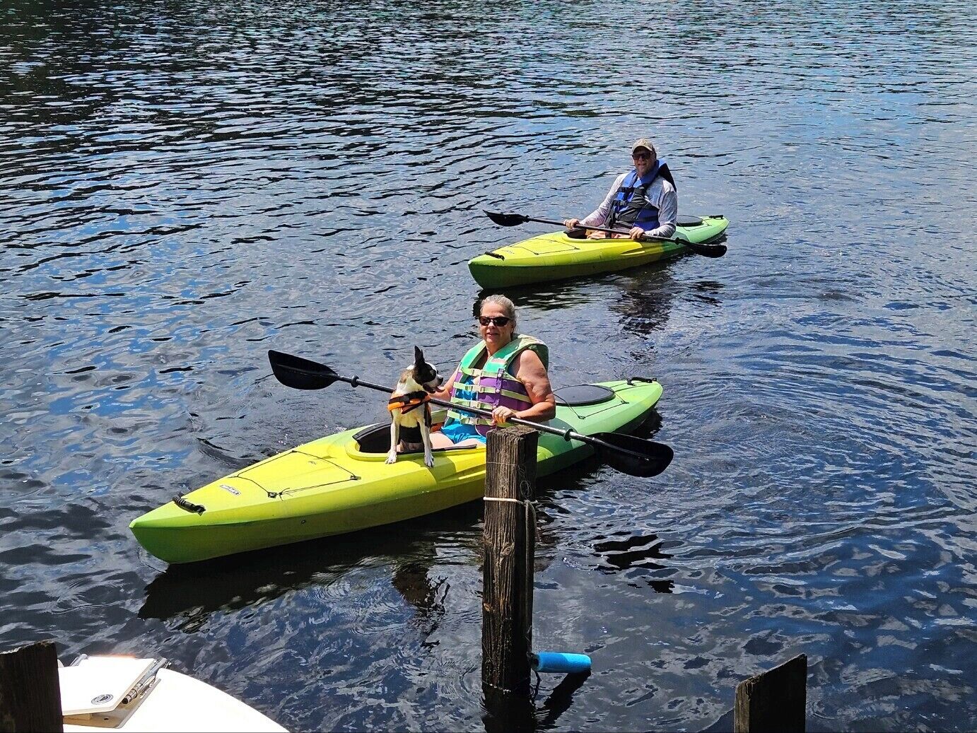 Two kayaks on calm water, tied to a dock.