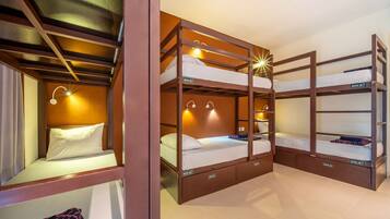 Habitación con literas de madera, cajones de almacenaje integrados y luces fijadas a la pared.