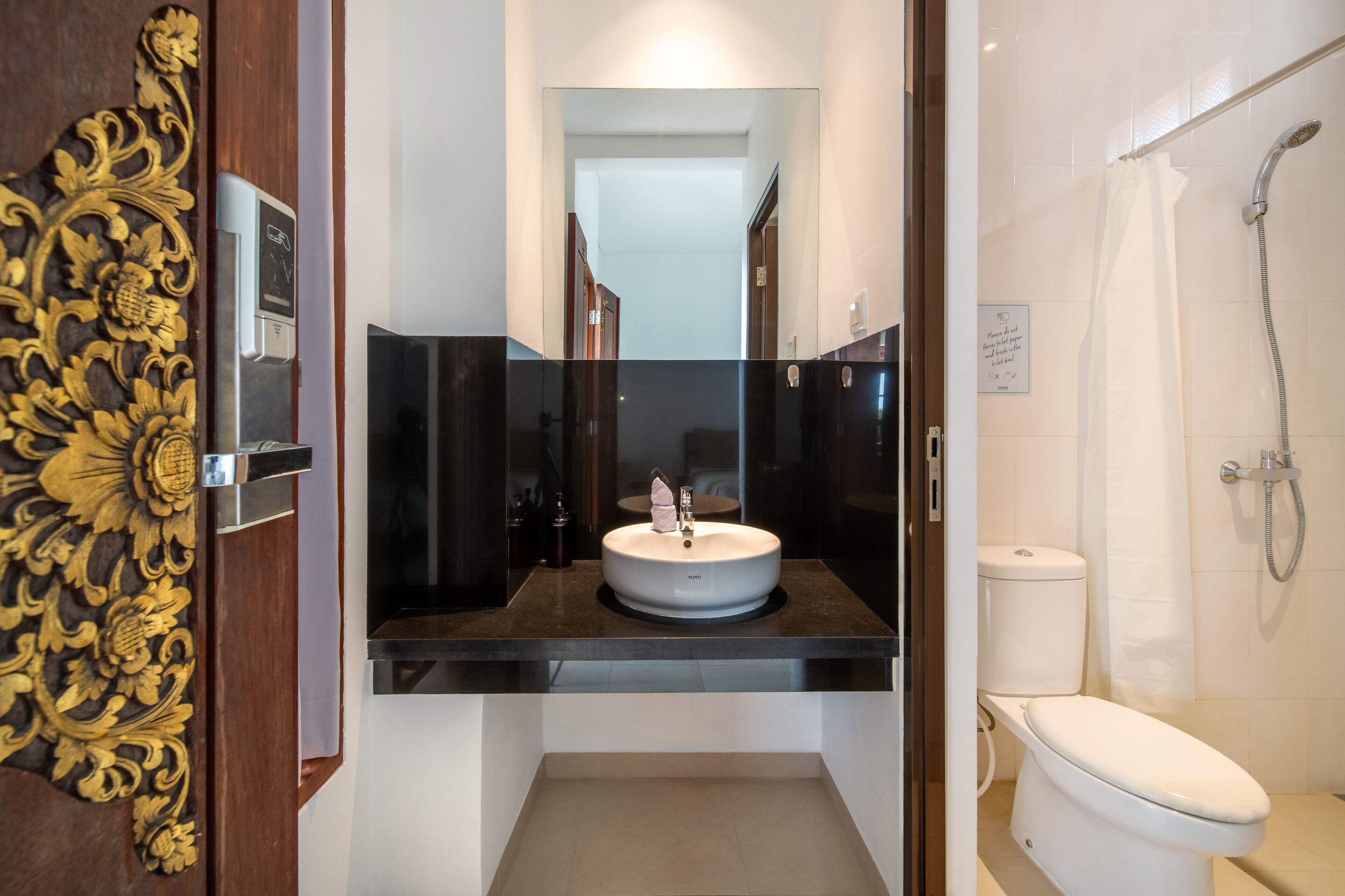 Un baño moderno con un lavamanos redondo, un inodoro y una ducha.