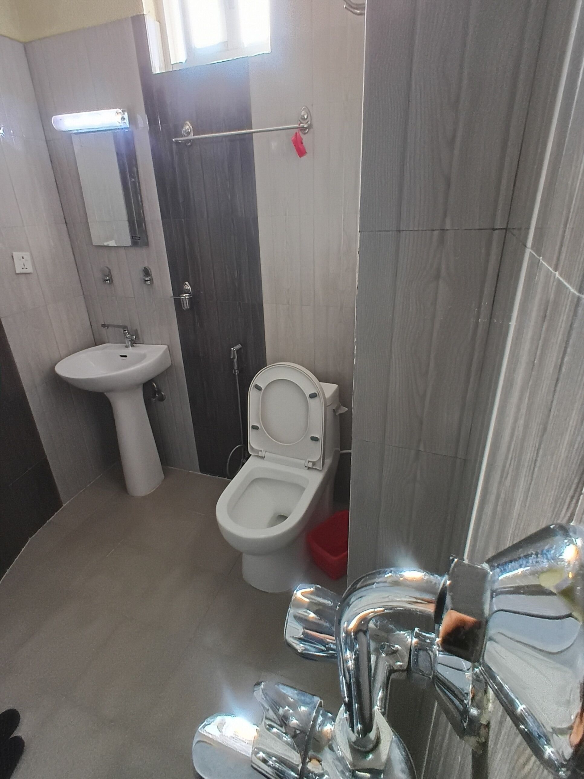 A bathroom with a sink, toilet, and mirror.