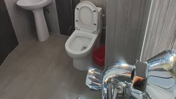 A bathroom with a sink, toilet, and mirror.
