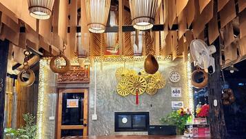 A reception area with a wooden reception desk, bamboo wall decor, and hanging bamboo lamps.