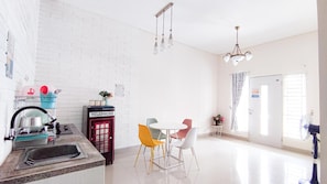 A modern kitchen with a sink, a telephone, and a dining area with a table and chairs.