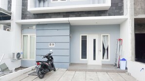 Een modern gebouw met een grijze gevel, een motorfiets ervoor en een bord met het nummer B9.